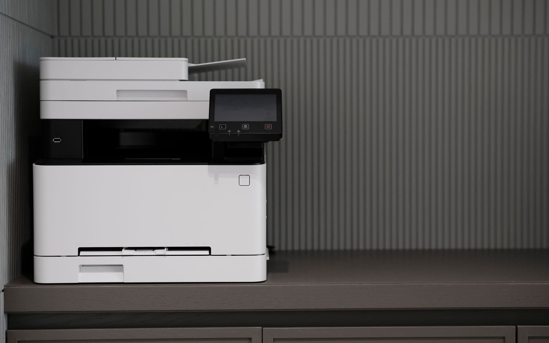 A modern white office multifunction printer in a clean, minimalist workspace